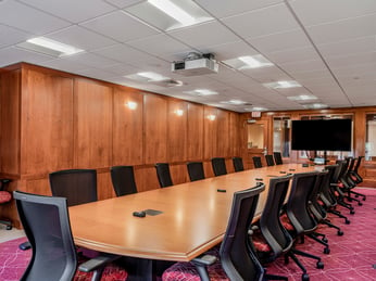 Interior, Percival Hall classroom at Fitchburg State University, Board Room Style table, chairs, whiteboard, monitor, etc.