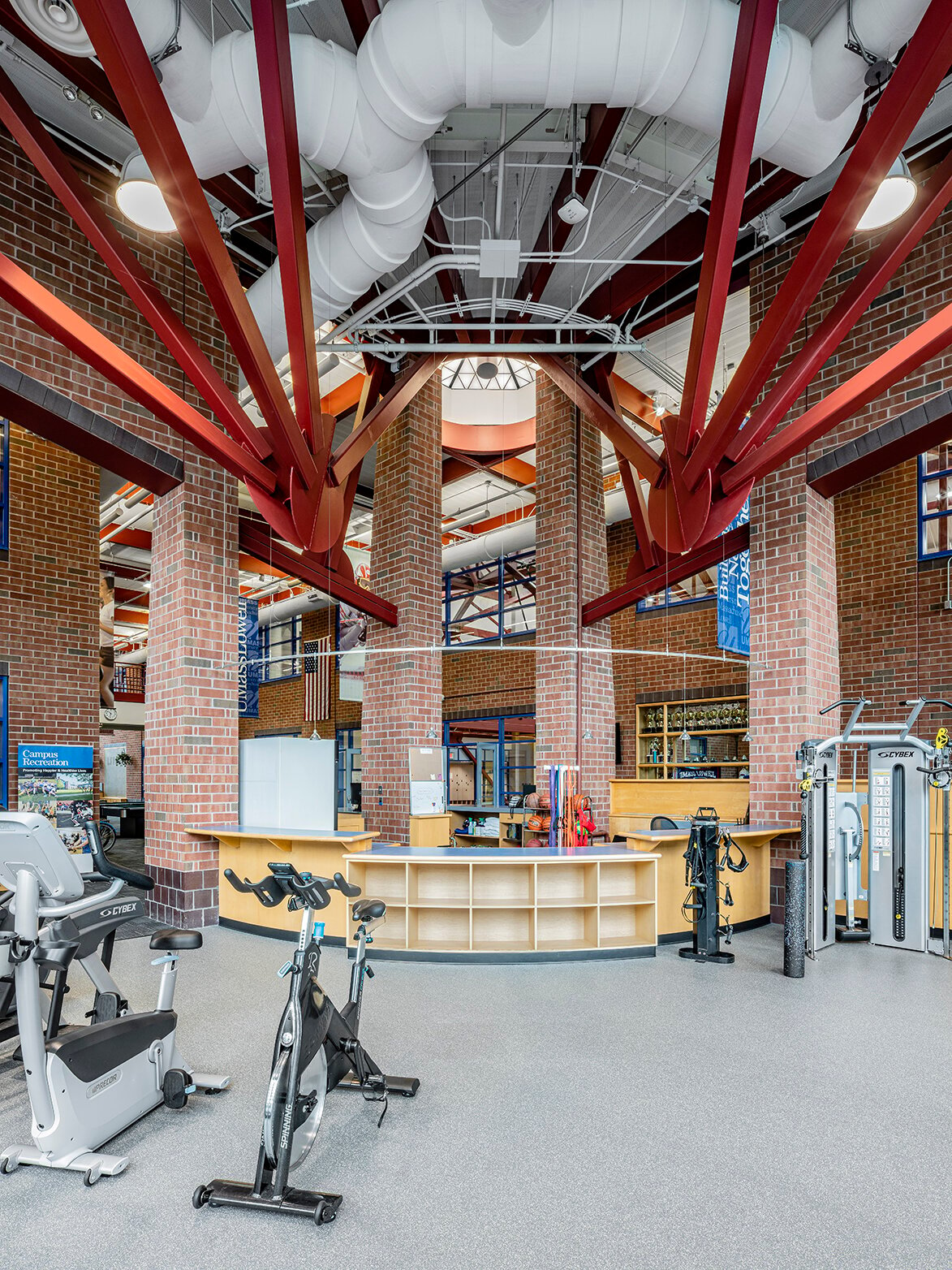 Interior, UMass Lowell Recreation and Guest Services area, guest services desk, various cardio equipment