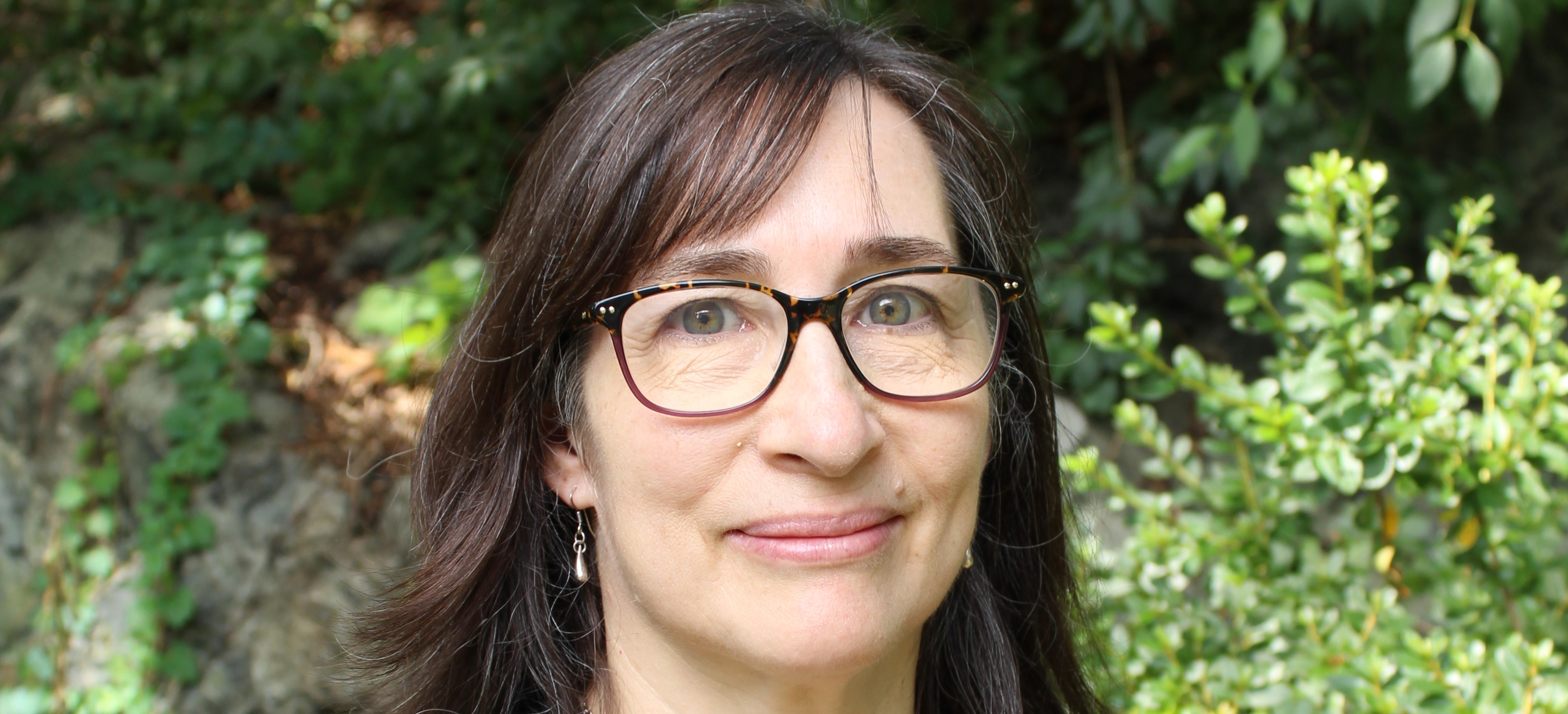 Headshot of Laura Notman against an outdoor background