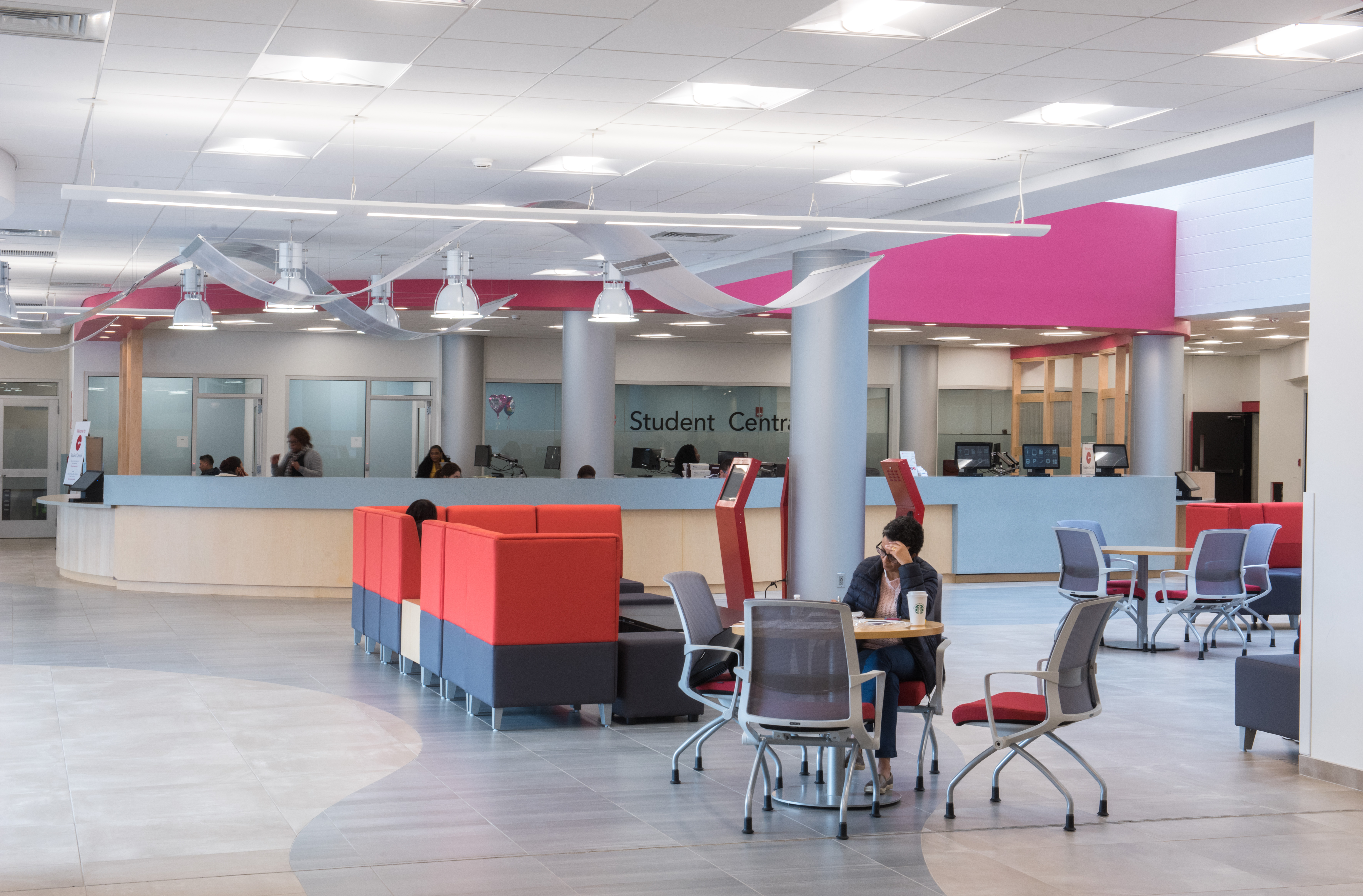 Interior, Student Central One Stop at Bunker Hill Community College, student services counter, kiosks, lounge furniture, café tables, chairs